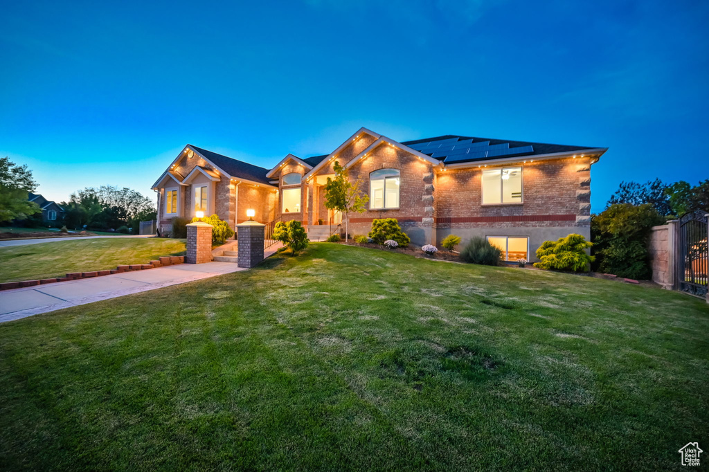 View of front of home featuring solar panels and brick siding