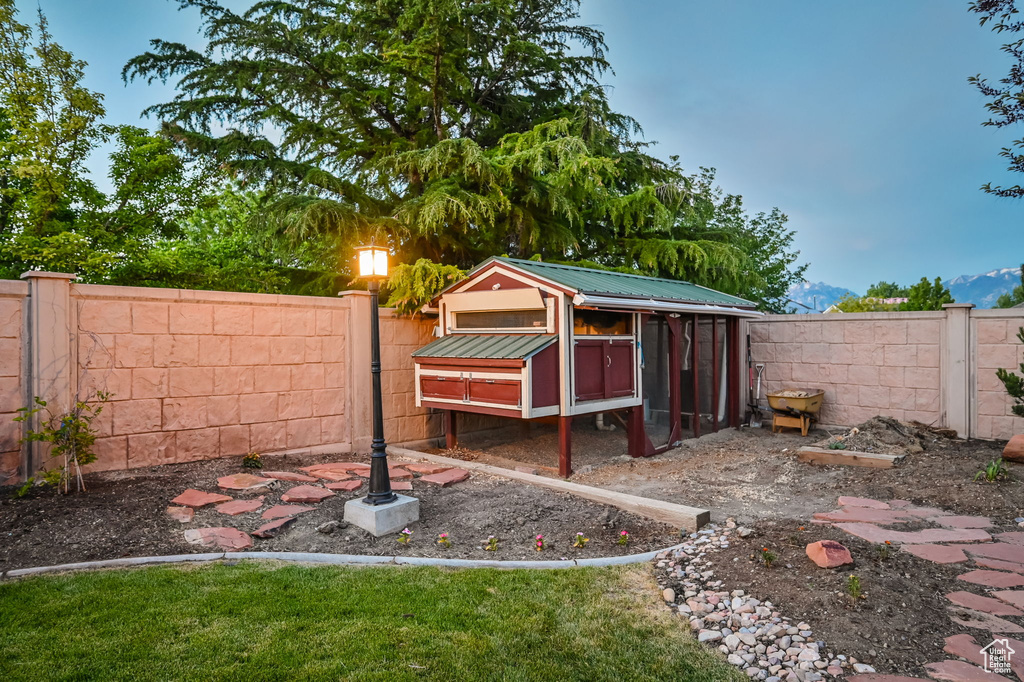 Fenced backyard featuring exterior structure and an outdoor structure