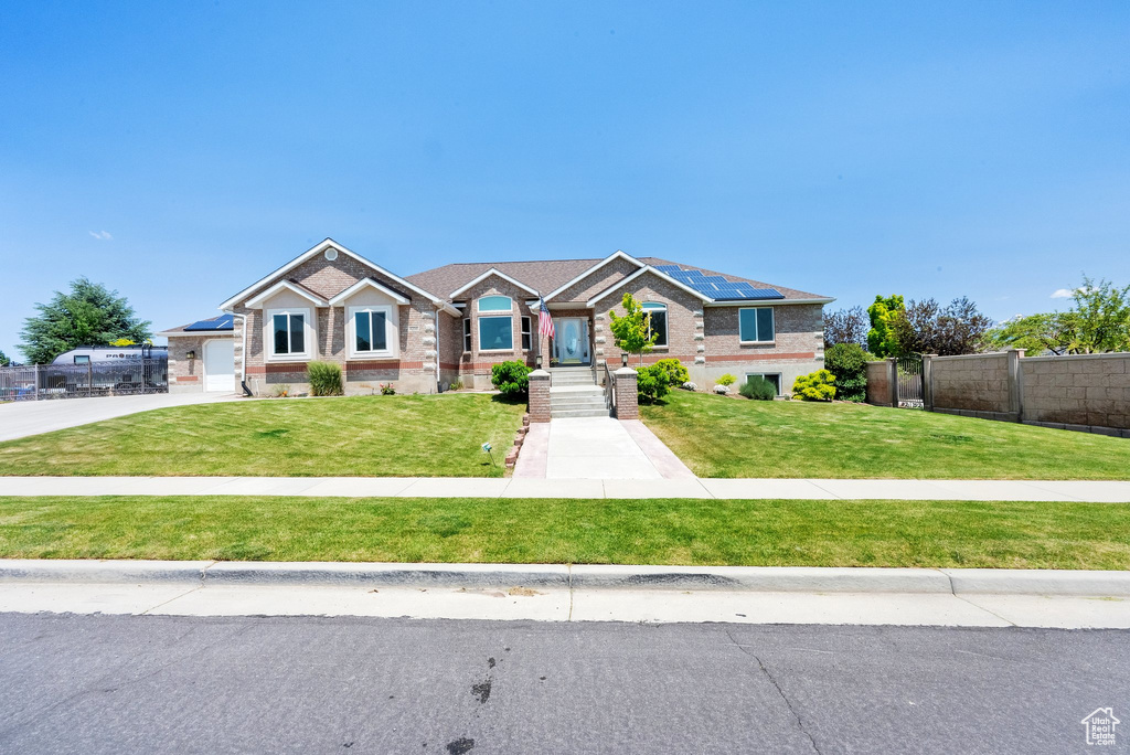View of front of property with brick siding and roof mounted solar panels