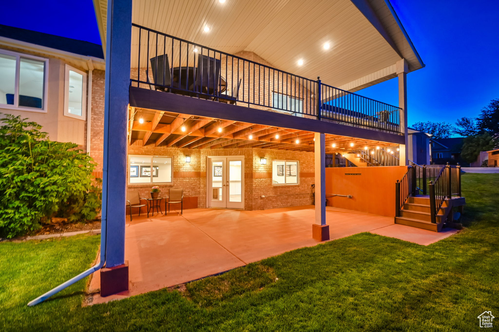 Patio at night featuring a patio and a lawn