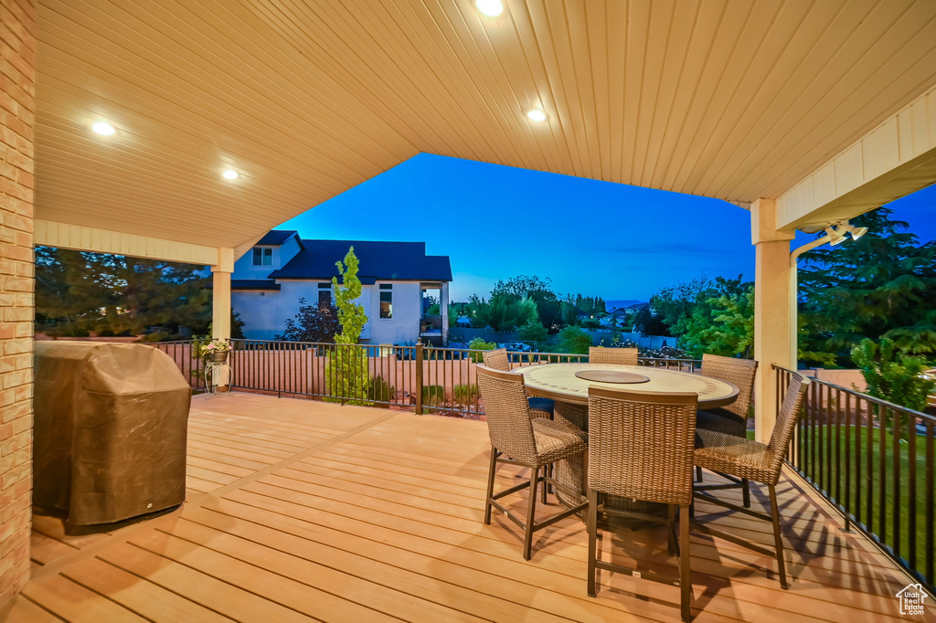 Wooden deck with outdoor dining area and a grill