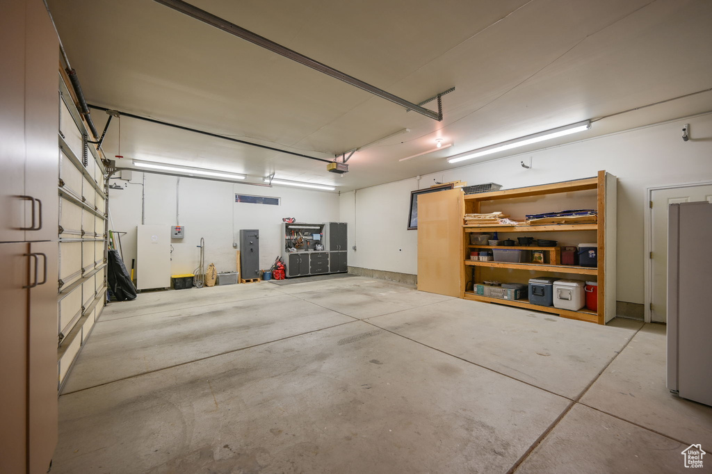 Garage featuring electric panel and a garage door opener