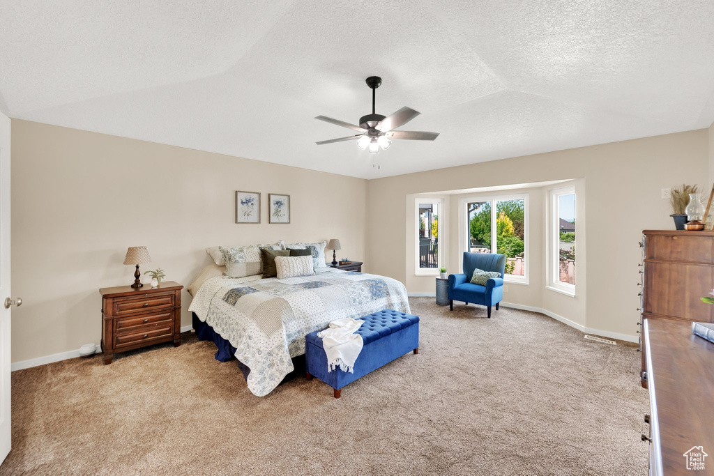 Bedroom featuring carpet flooring, baseboards, a textured ceiling, ceiling fan, and lofted ceiling