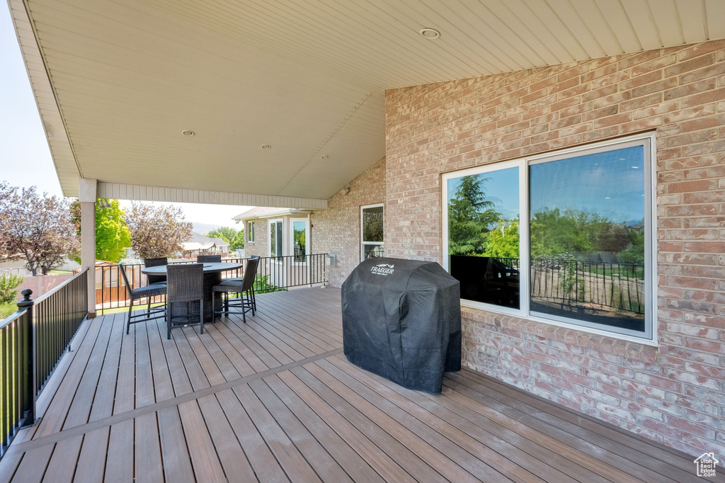 Wooden terrace with a grill and outdoor dining area