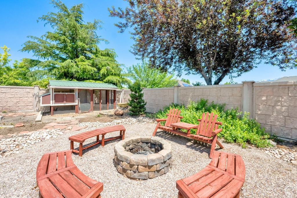 Fenced backyard featuring an outdoor fire pit and exterior structure