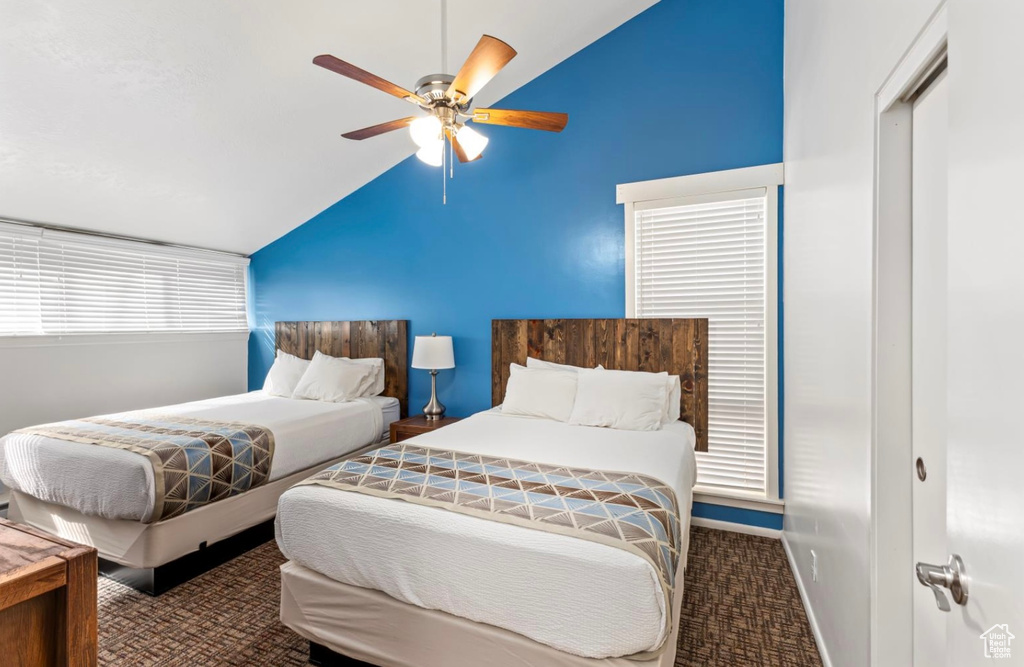 Bedroom featuring lofted ceiling, ceiling fan, baseboards, and carpet