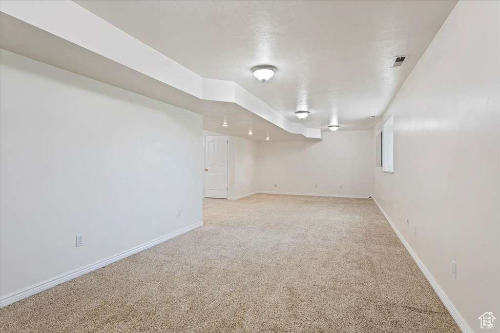 Finished basement featuring light carpet and baseboards