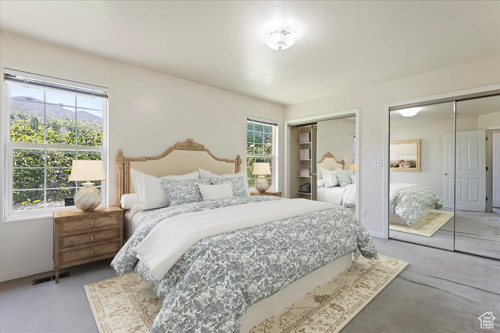Carpeted bedroom featuring two closets and baseboards