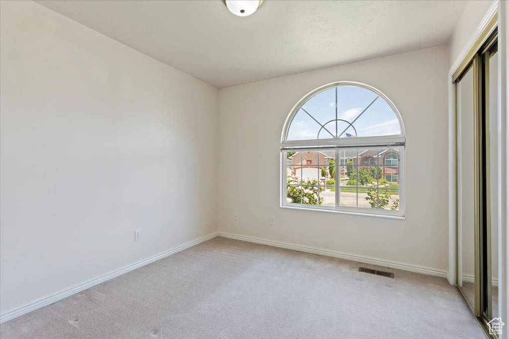 Unfurnished bedroom with light colored carpet, baseboards, and a closet
