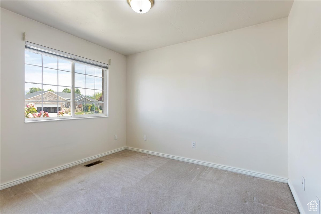 Spare room with light carpet and baseboards