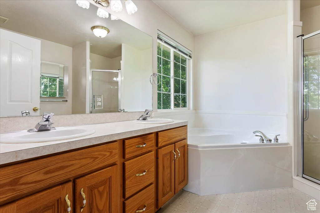 Full bath with a shower stall, a bath, and double vanity
