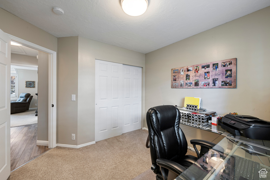 Home office with baseboards and carpet