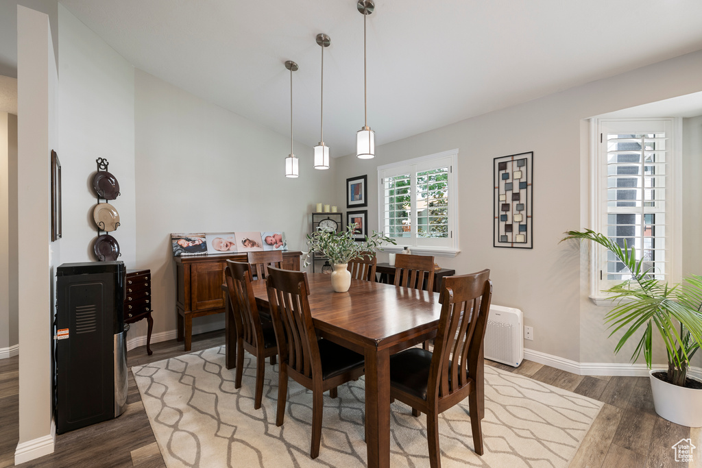 Dining area featuring light wood-style floors, baseboards, and vaulted ceiling