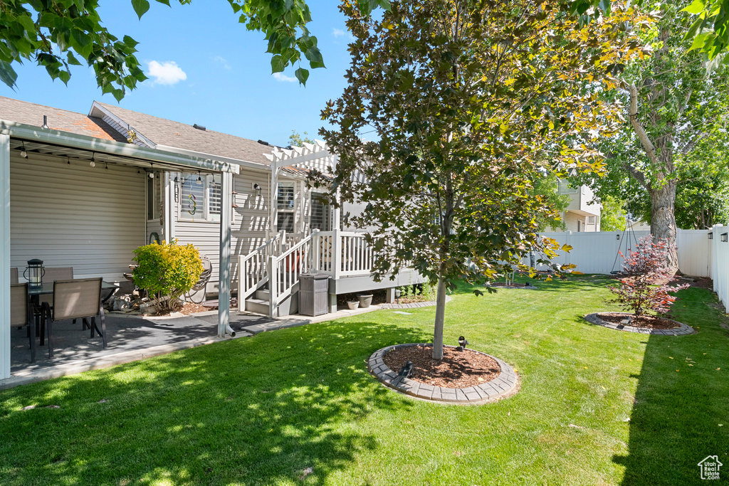 View of yard featuring a pergola, a wooden deck, and a patio
