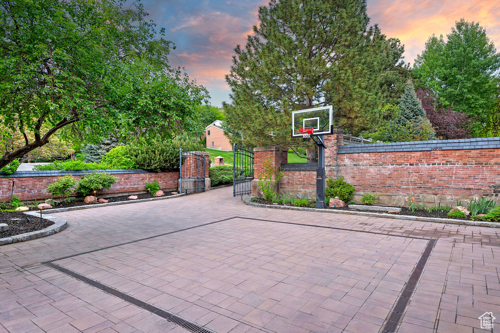View of patio / terrace with basketball hoop and a gate