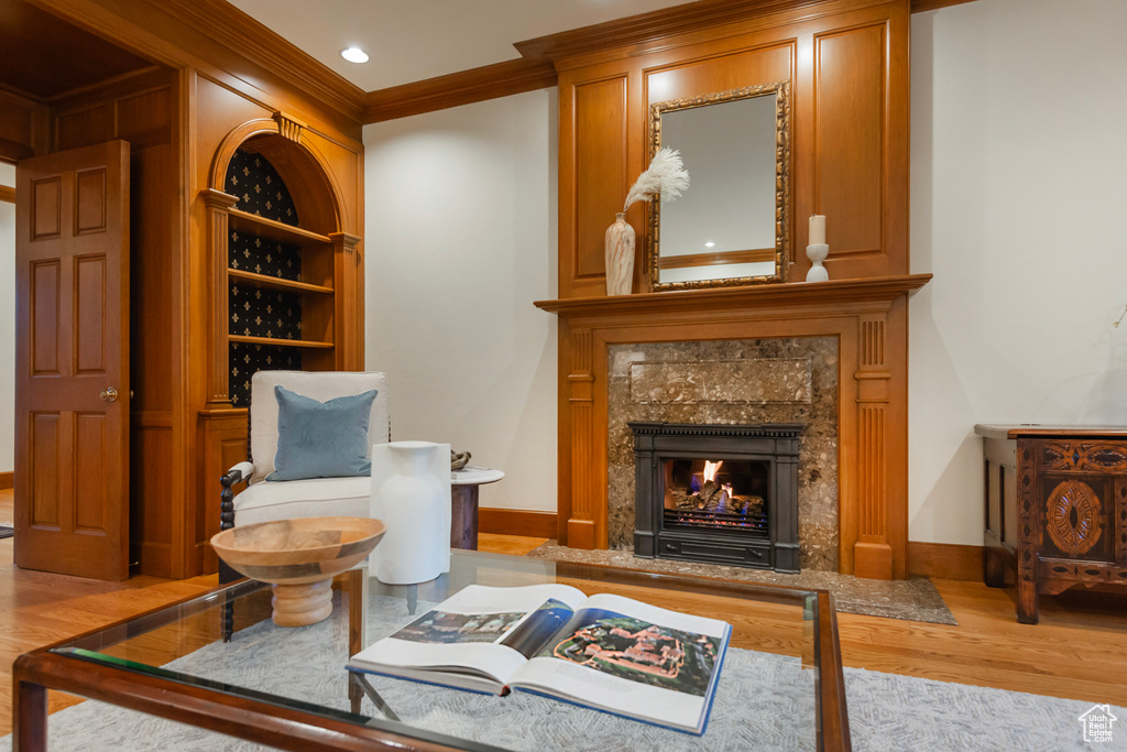 Living room with wood finished floors, ornamental molding, baseboards, a fireplace, and recessed lighting