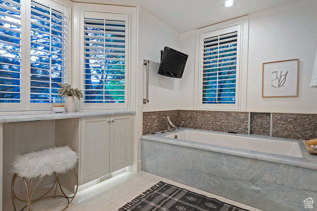 Bathroom featuring a bath, tile patterned flooring, and recessed lighting
