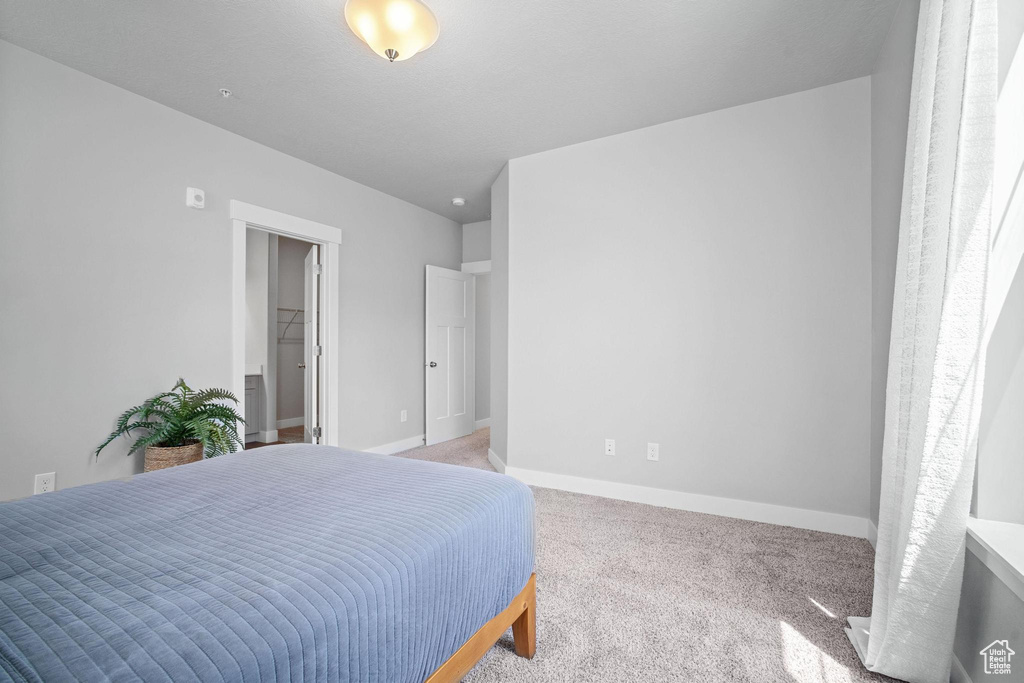 Bedroom featuring carpet and baseboards