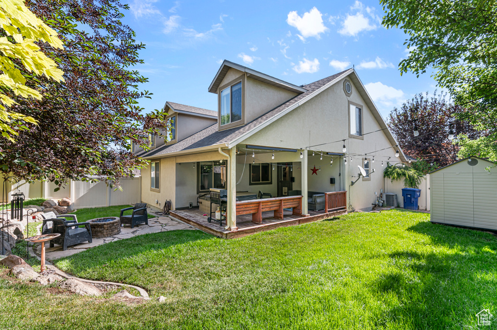 Back of house with a fire pit, stucco siding, roof with shingles, a patio area, and cooling unit