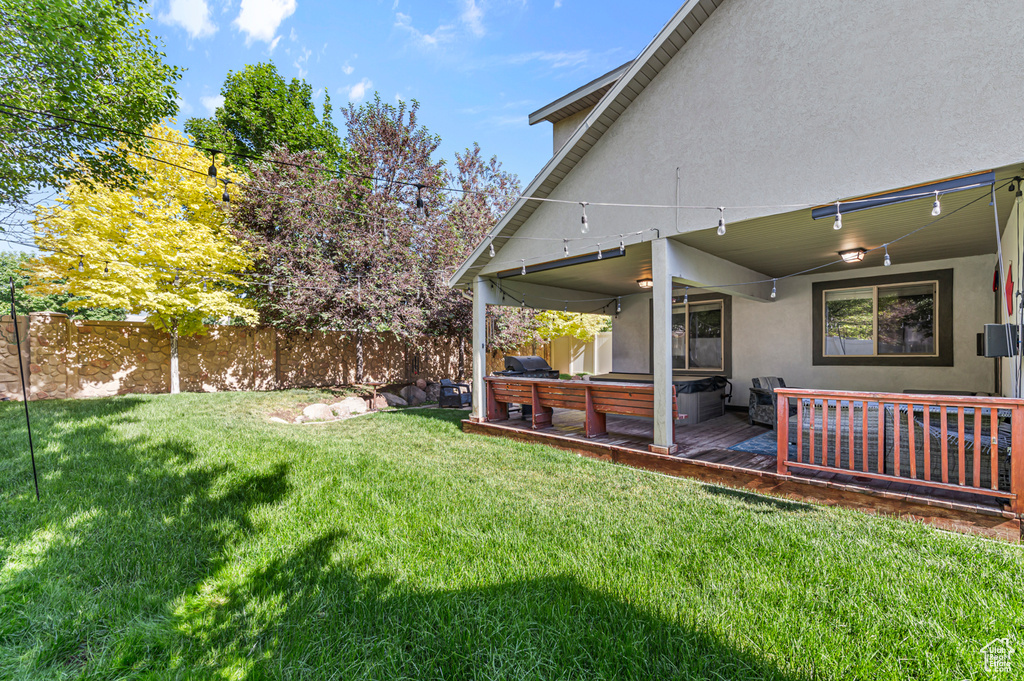 View of yard with a wooden deck and a hot tub