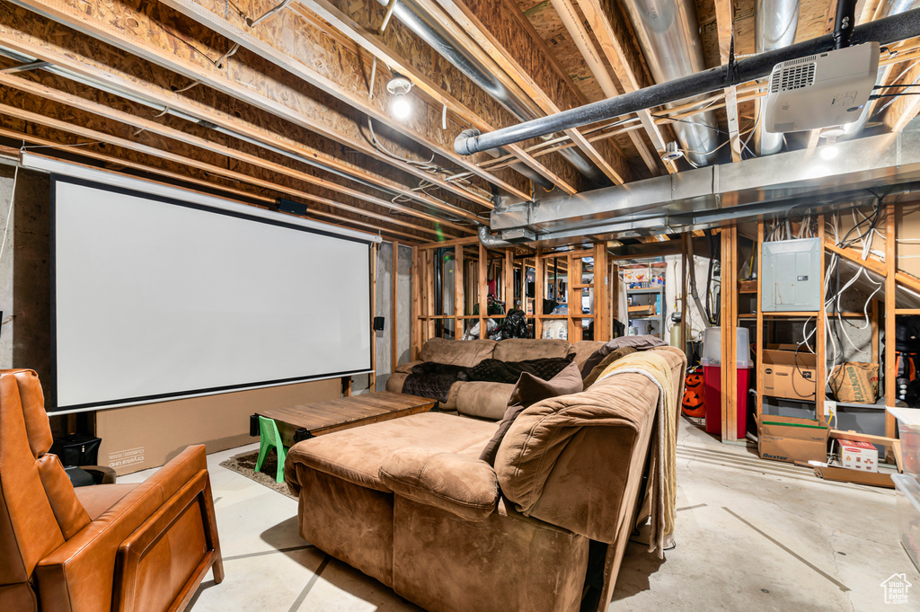 Home theater room featuring unfinished concrete flooring and electric panel