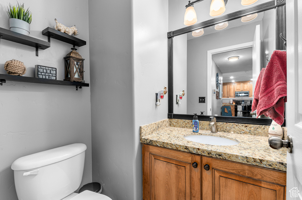 Half bathroom with toilet and vanity