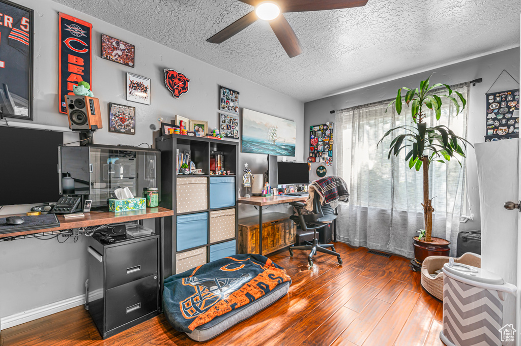 Office with a textured ceiling, hardwood / wood-style floors, and ceiling fan