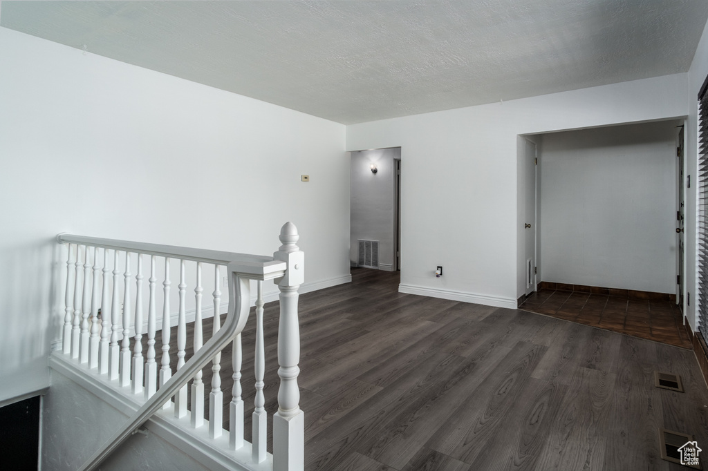 Unfurnished room featuring dark wood-style floors and baseboards