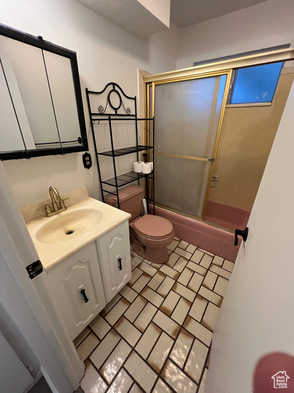 Full bathroom featuring vanity and shower / bath combination with glass door