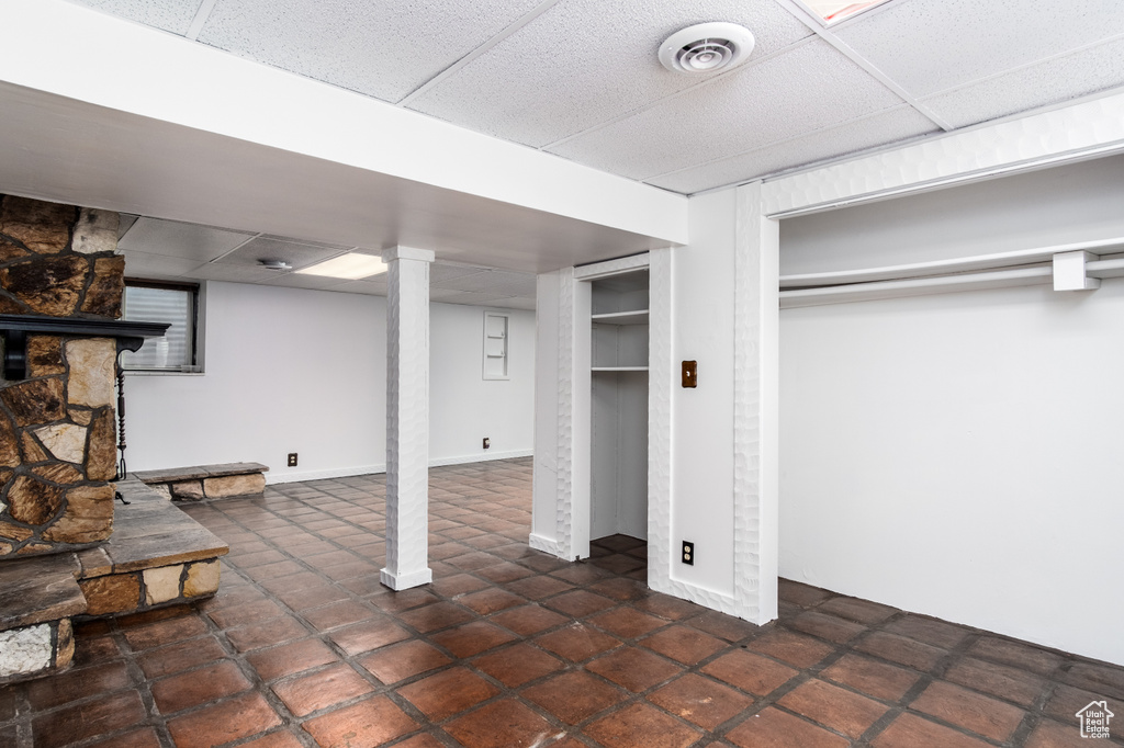 Finished basement featuring a drop ceiling and tile patterned flooring