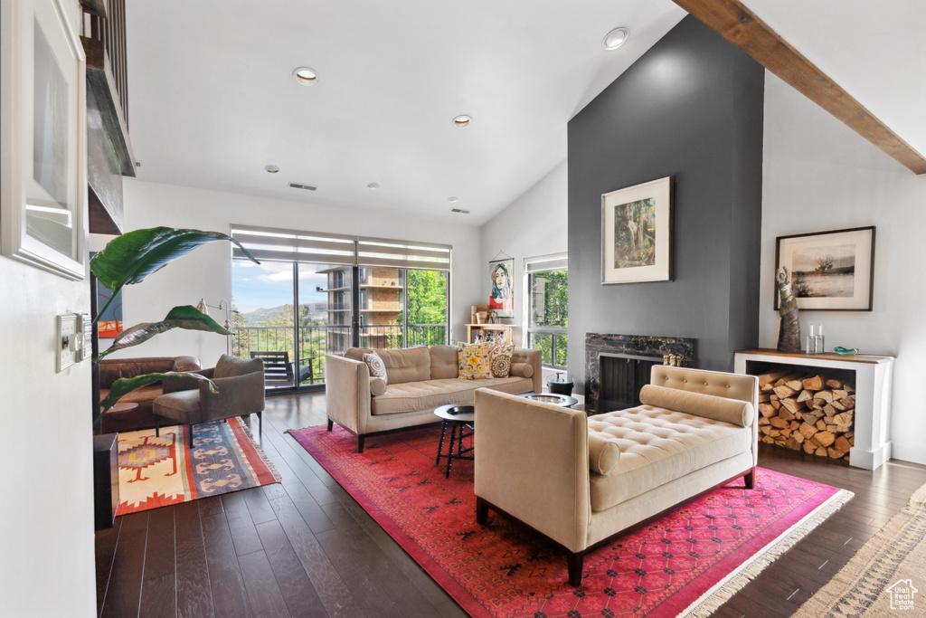 Living room with lofted ceiling, hardwood / wood-style floors, a fireplace, and recessed lighting
