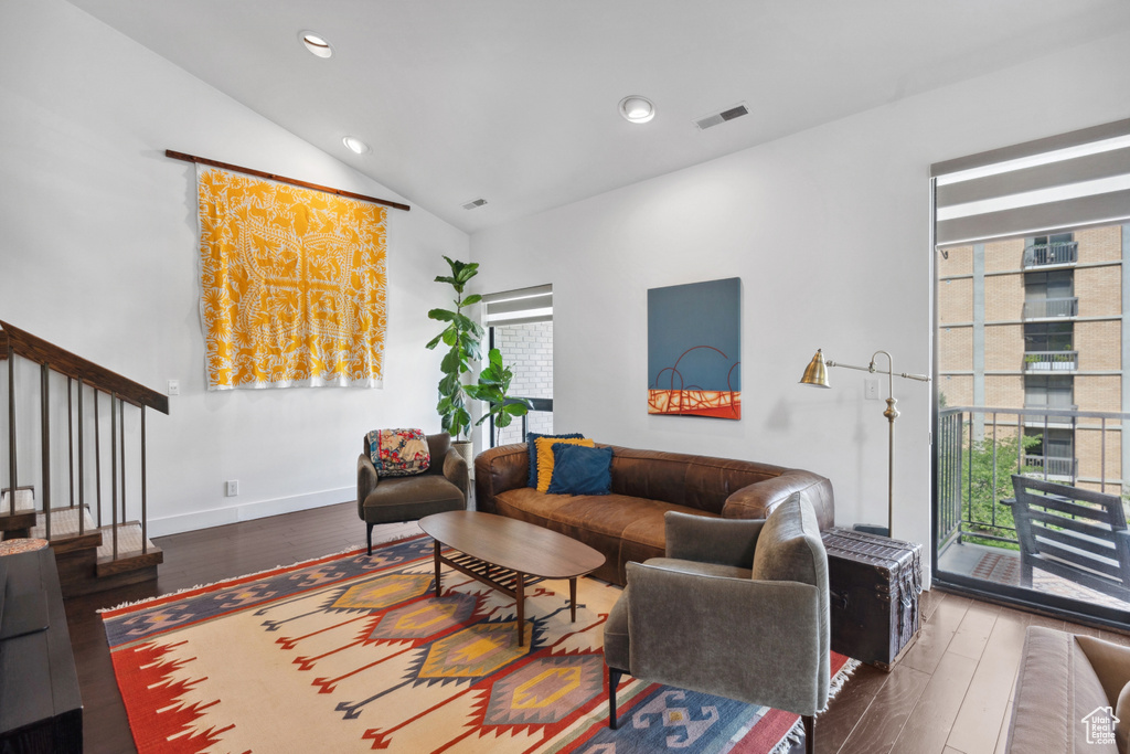 Living room with wood-type flooring, vaulted ceiling, recessed lighting, and baseboards