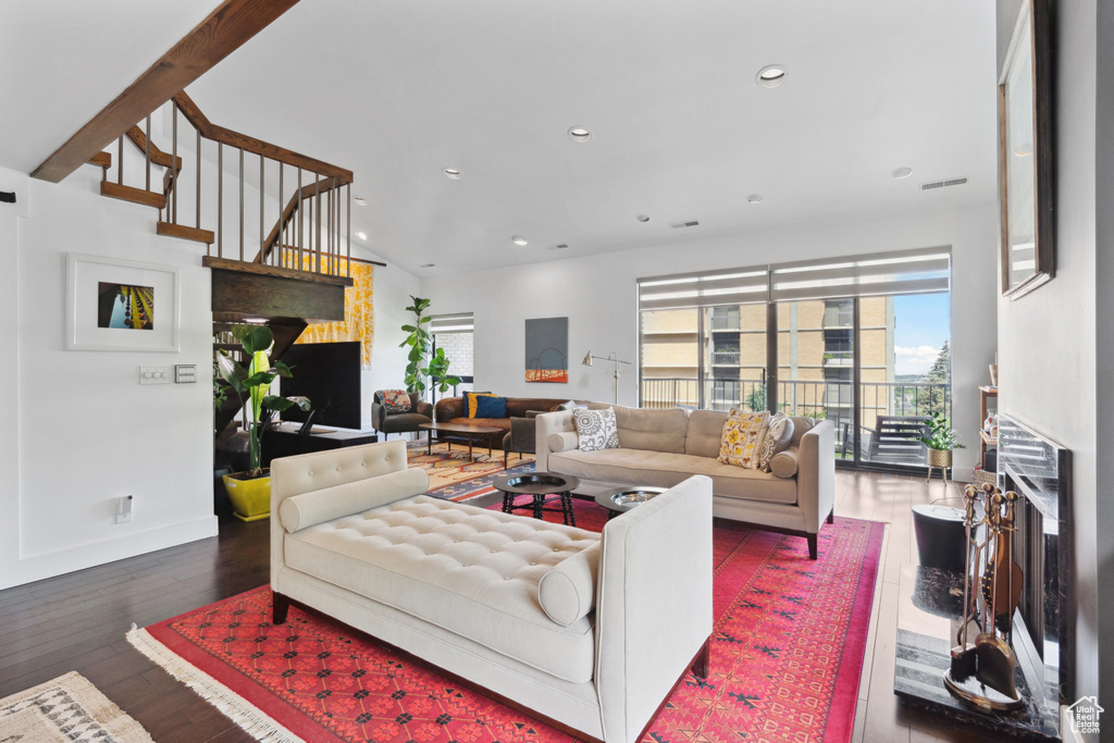 Living room with recessed lighting, wood-type flooring, a fireplace, and stairway