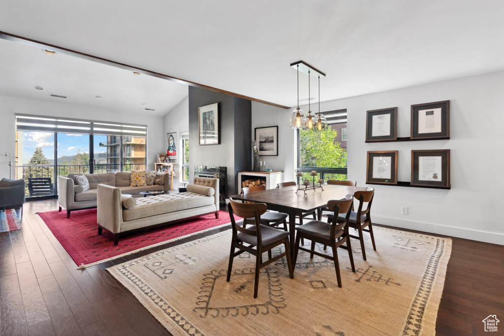 Dining room featuring plenty of natural light, hardwood / wood-style floors, baseboards, and lofted ceiling