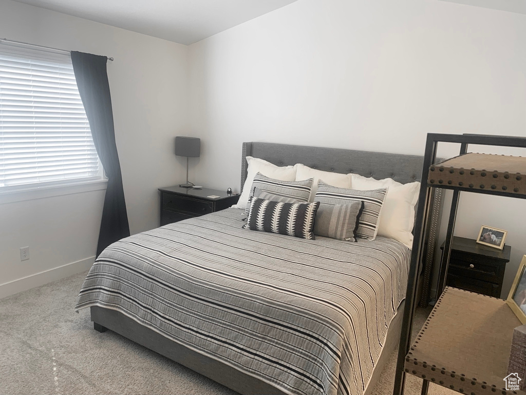 Bedroom featuring carpet and baseboards