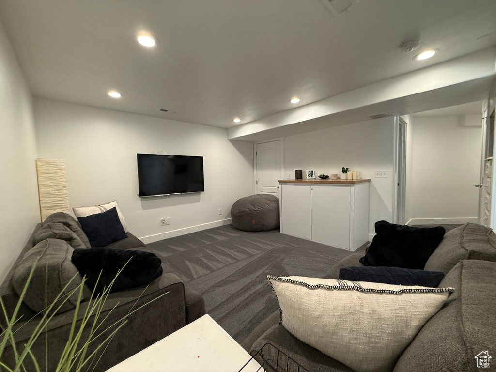 Living room featuring dark colored carpet, recessed lighting, and baseboards