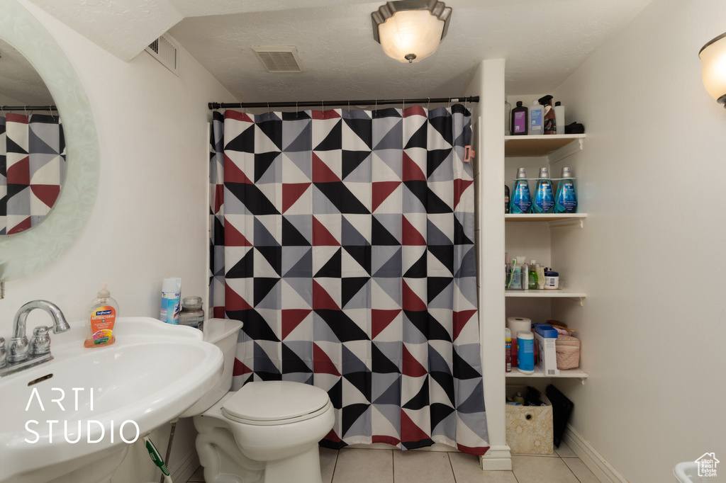 Bathroom with tile patterned floors, toilet, and a shower with curtain