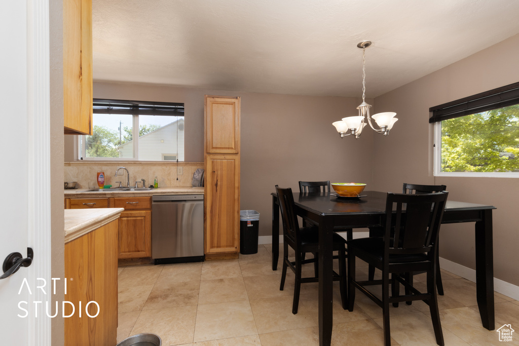 Dining space with healthy amount of natural light, a chandelier, and light tile patterned flooring