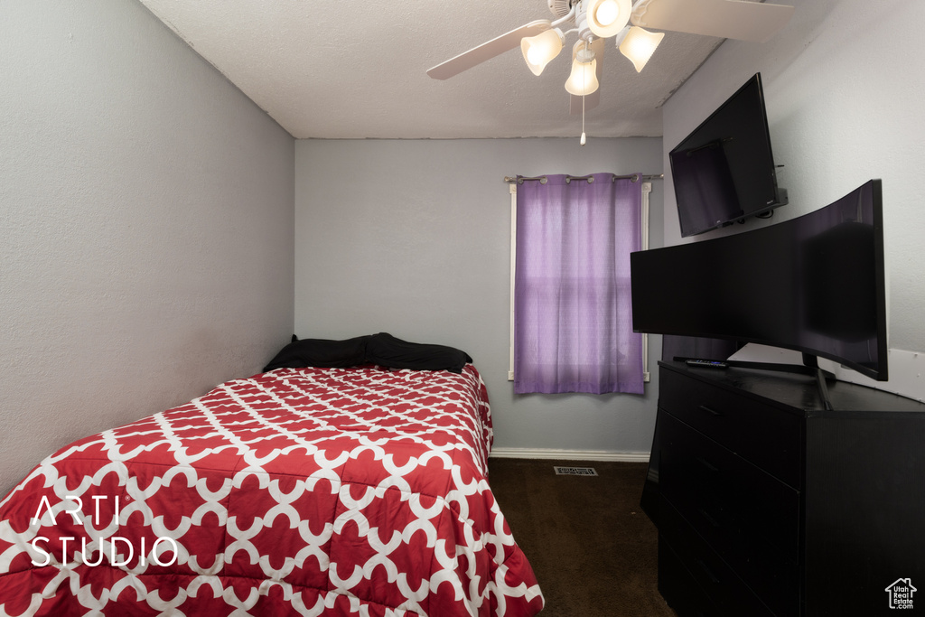 Carpeted bedroom with a ceiling fan and baseboards