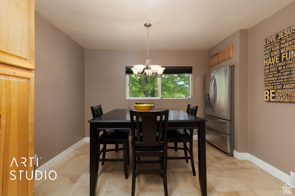 Dining area with a chandelier, light tile patterned floors, and baseboards