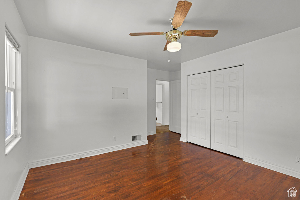 Unfurnished bedroom featuring wood finished floors, baseboards, a closet, and ceiling fan