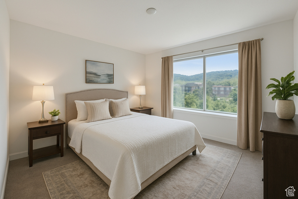 Bedroom featuring light carpet, baseboards, and a mountain view
