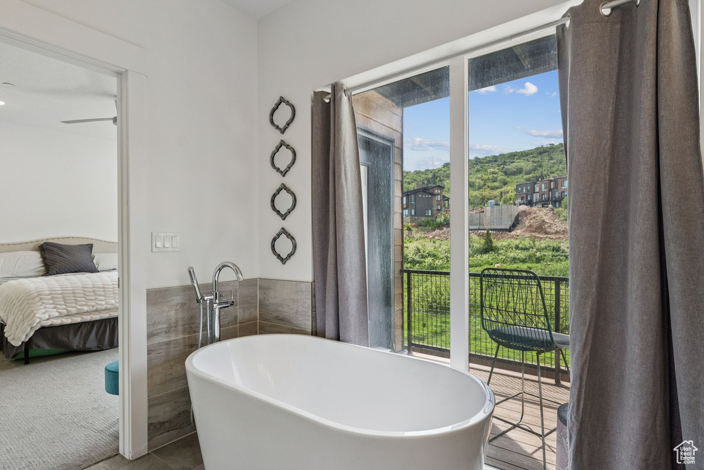 Bathroom featuring a freestanding bath, connected bathroom, and tile patterned flooring