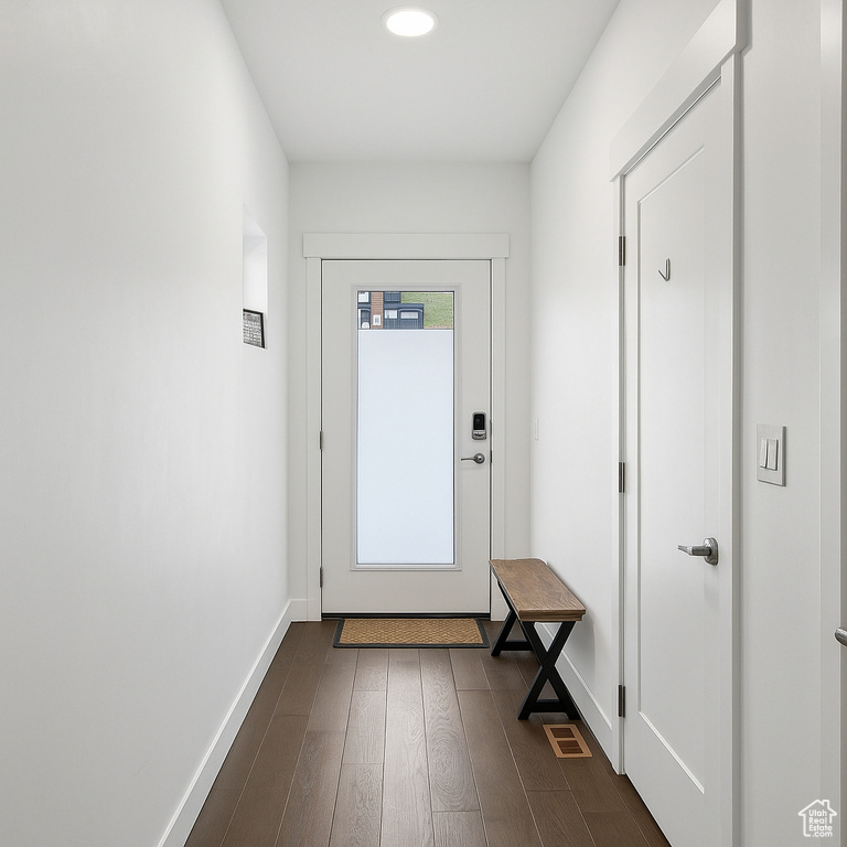 Doorway to outside featuring dark wood-style flooring, baseboards, and recessed lighting