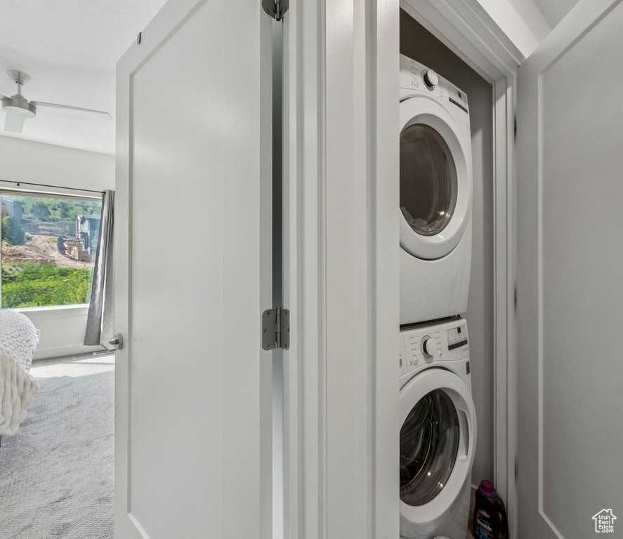 Washroom featuring stacked washer / dryer and carpet floors