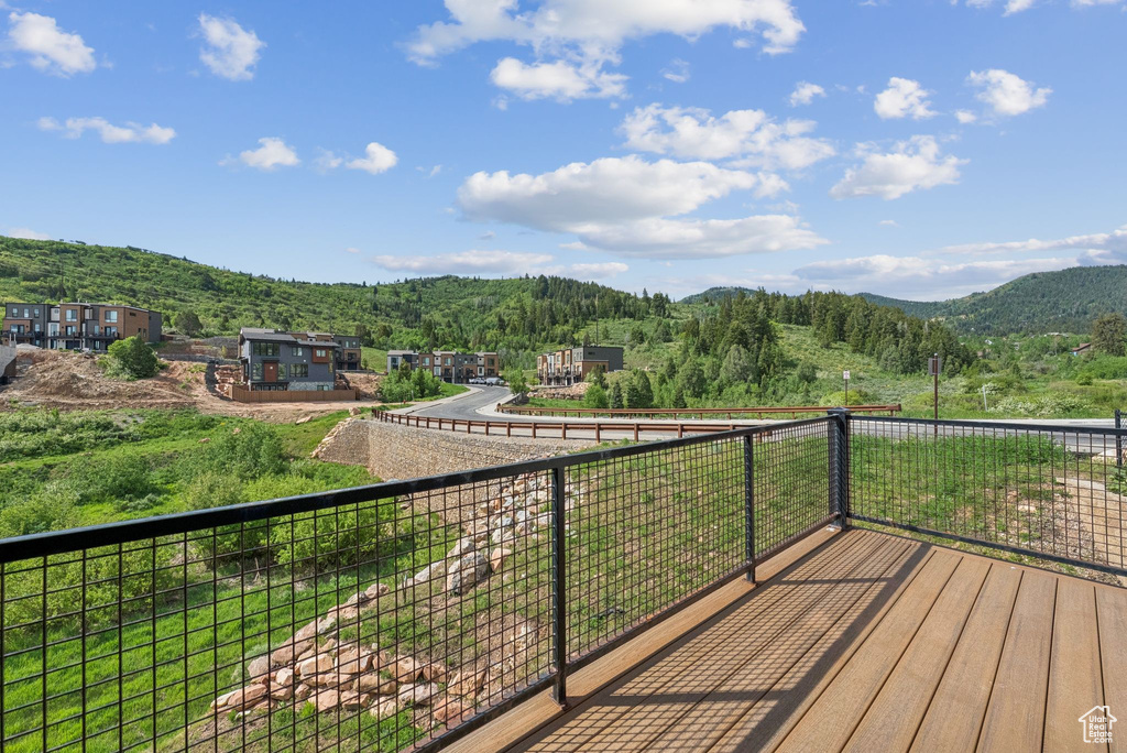 Wooden deck featuring a mountain view and a view of trees