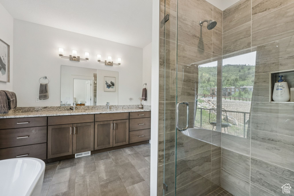 Bathroom featuring a stall shower, vanity, and a freestanding bath