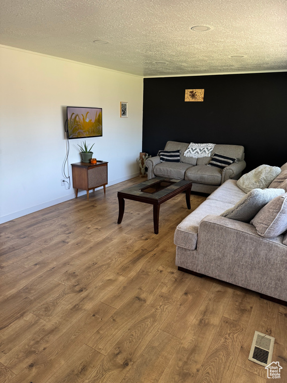 Living area featuring wood finished floors and a textured ceiling