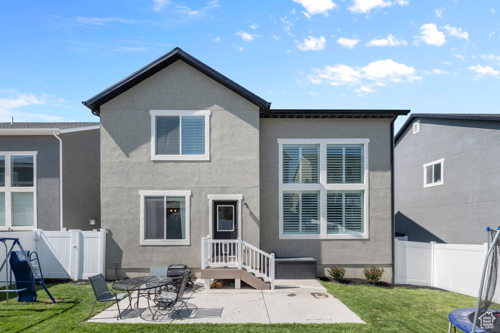 Rear view of house with stucco siding and a patio