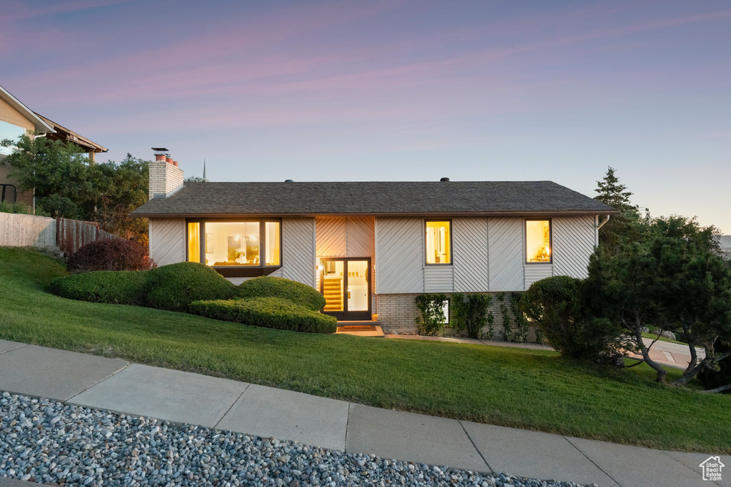 Raised ranch featuring a chimney and brick siding